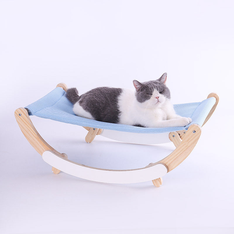 black and white cat laying blue hammock rocking chair white background