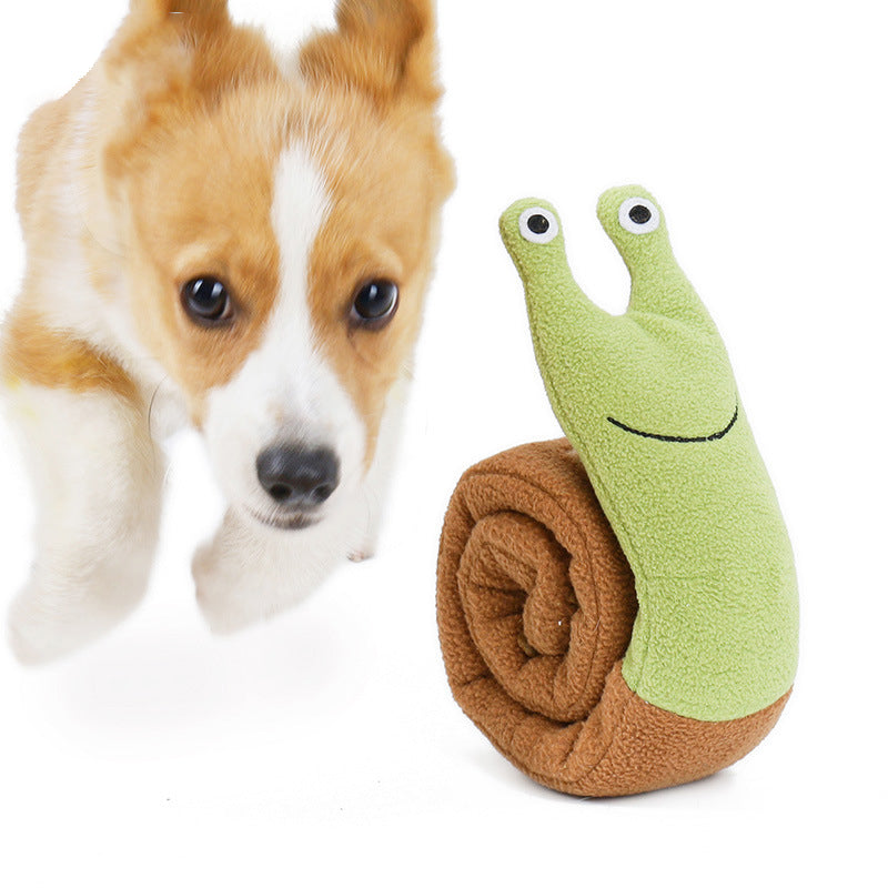 dog playing snail plush toy